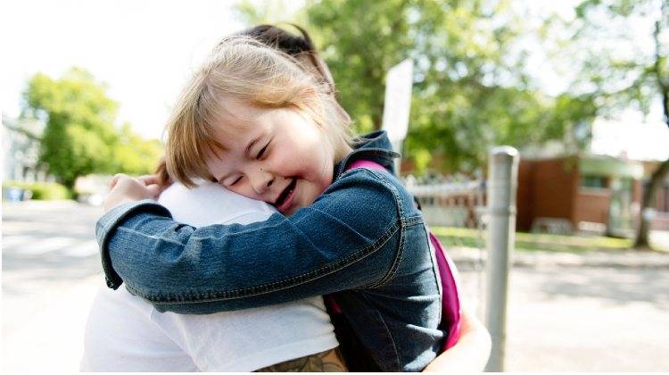 Abbraccio tra genitore e figlia down