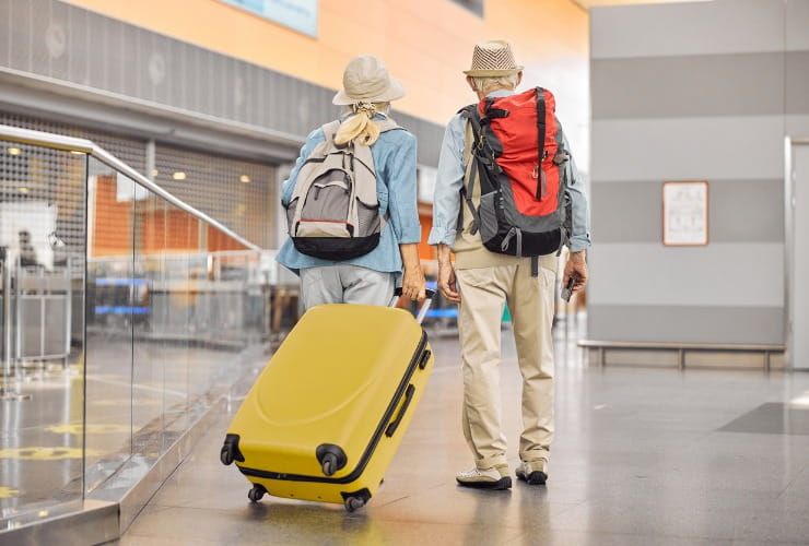 Due viaggiatori anziani in piedi all'aeroporto 