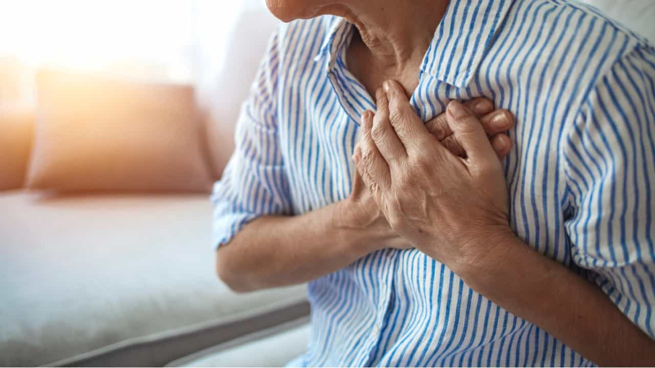 Heart attack, mature mature woman touches her chest with pain