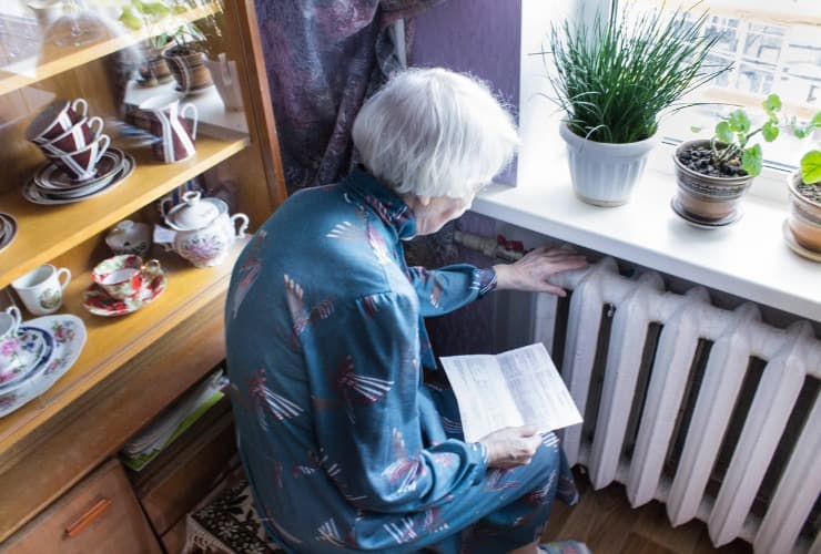 Anziana donna accanto al calorifero 