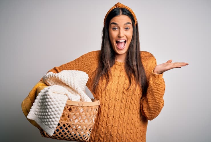 Giovane donna con vestiti nel cesto 