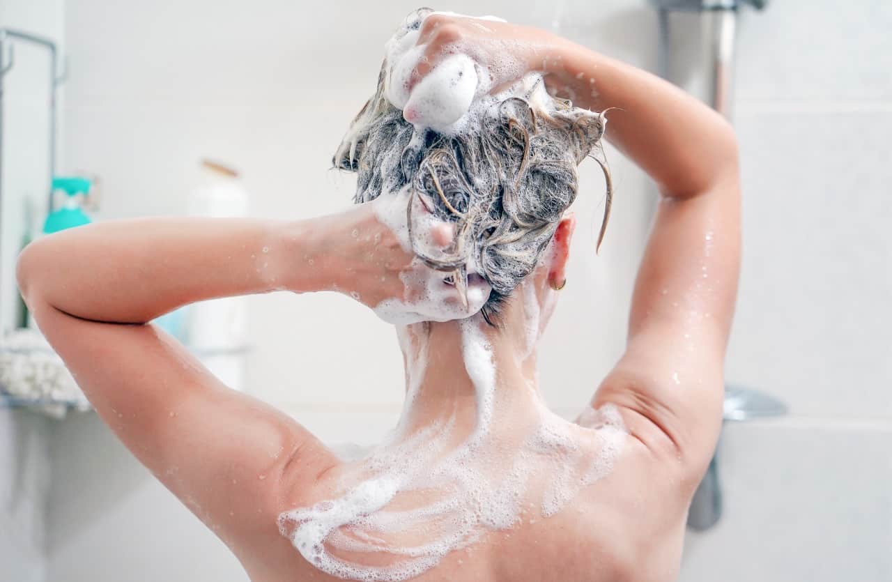 Giovane donna si lava i capelli