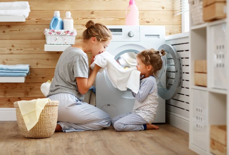 Madre casalinga e bambino vicini alla lavatrice