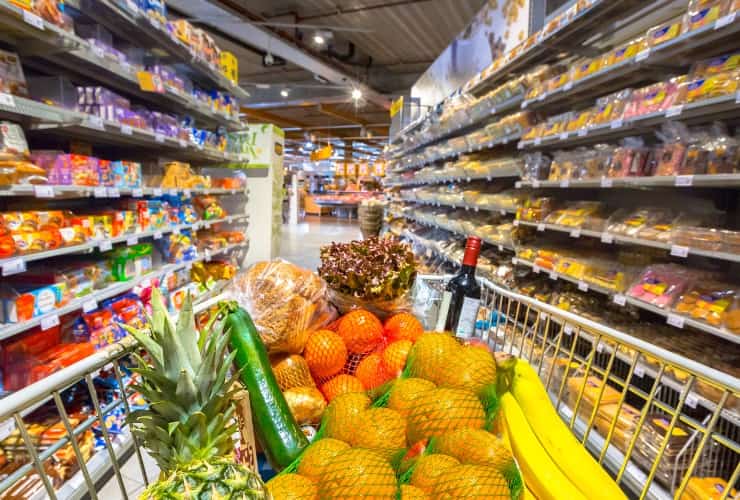 Carrello pieno nella corsia del supermercato