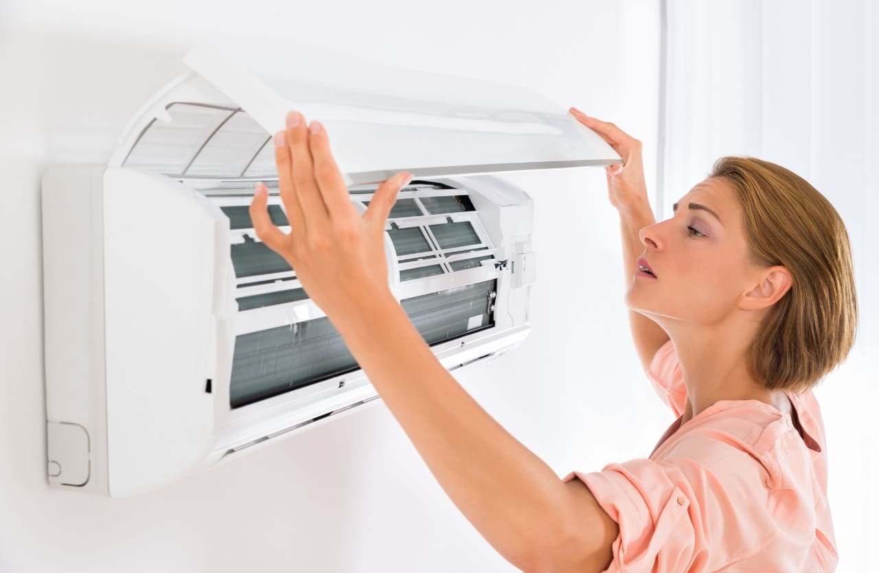 Woman looks at open air conditioner