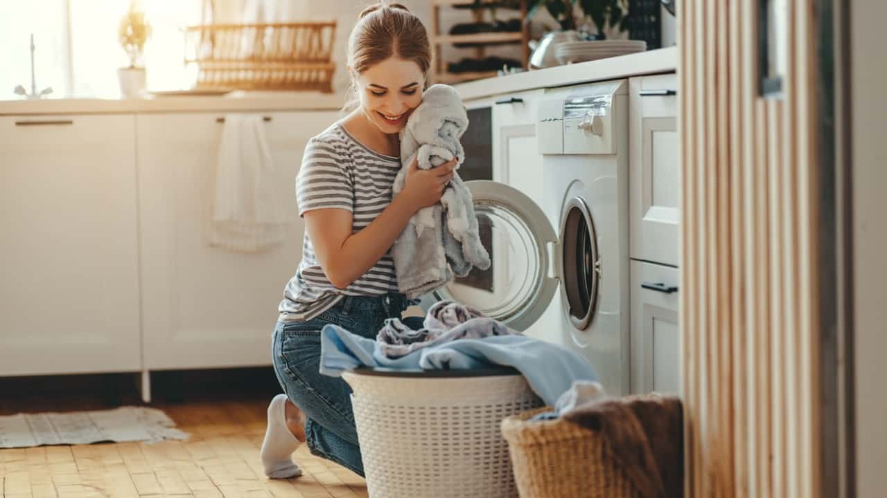 Donna in lavanderia con lavatrice