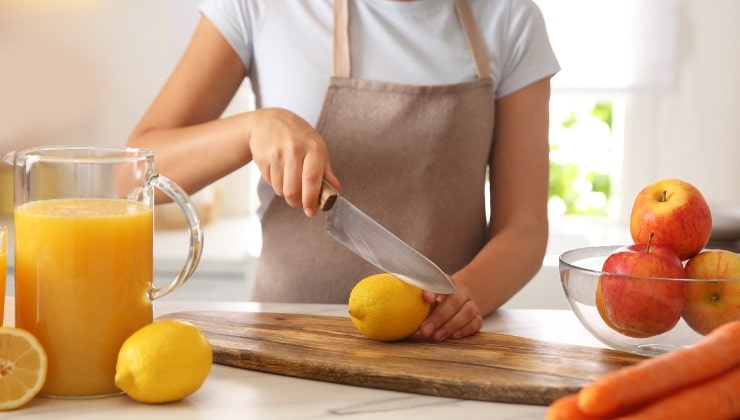 Giovane donna taglia un limone