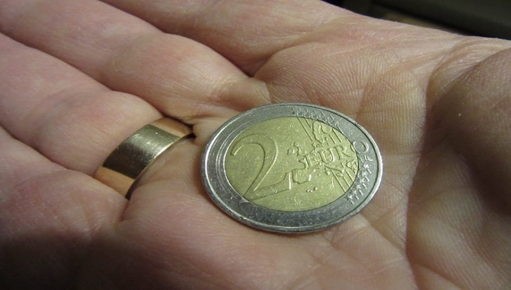 Mano con moneta da 2 euro 