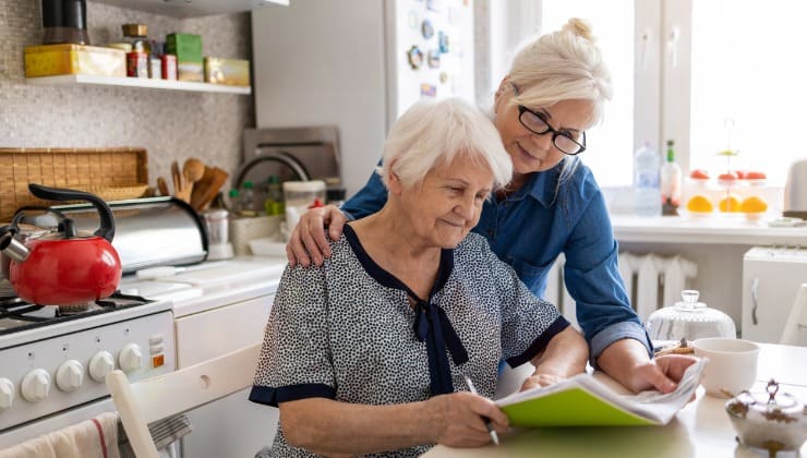 Donna aiuta madre anziana con documenti 