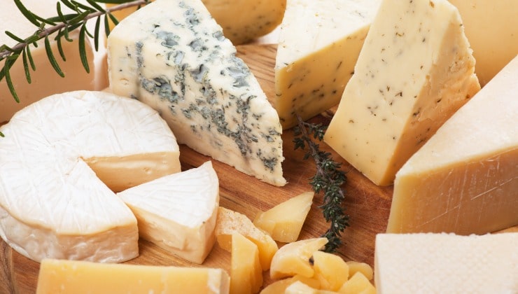 Assorted cheeses on wooden cutting board