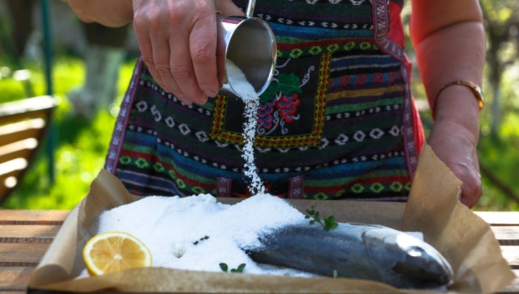 Femme prépare du poisson au sel