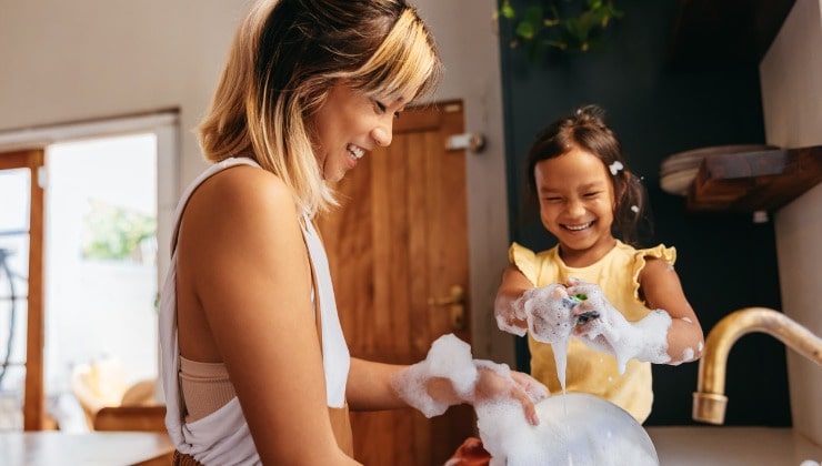 Mamma e figlia lavano i piatti 